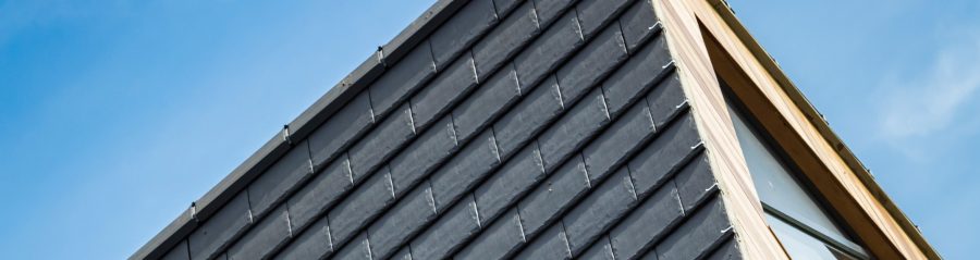Gable end of red tiled roof with white walls