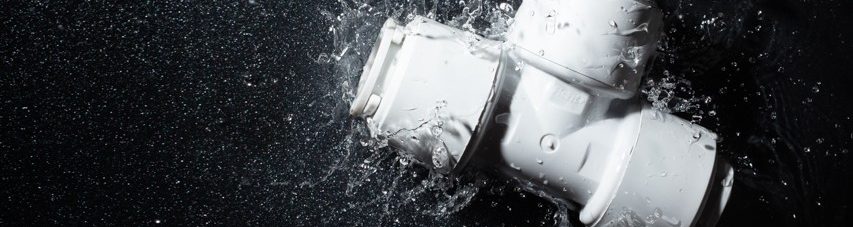white plastic plumbing product falling into water