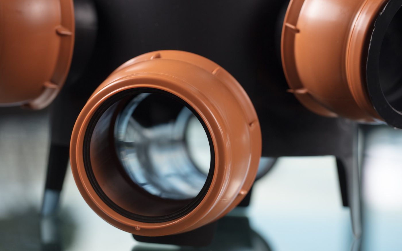 Close-up of brown plastic drainage pipe fittings with rubber seals.