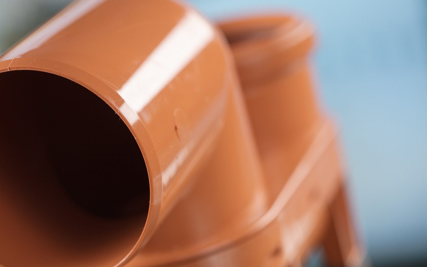 Angled view of a smooth brown plastic pipe connector.