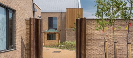 Open gateway in brick wall looking in garden