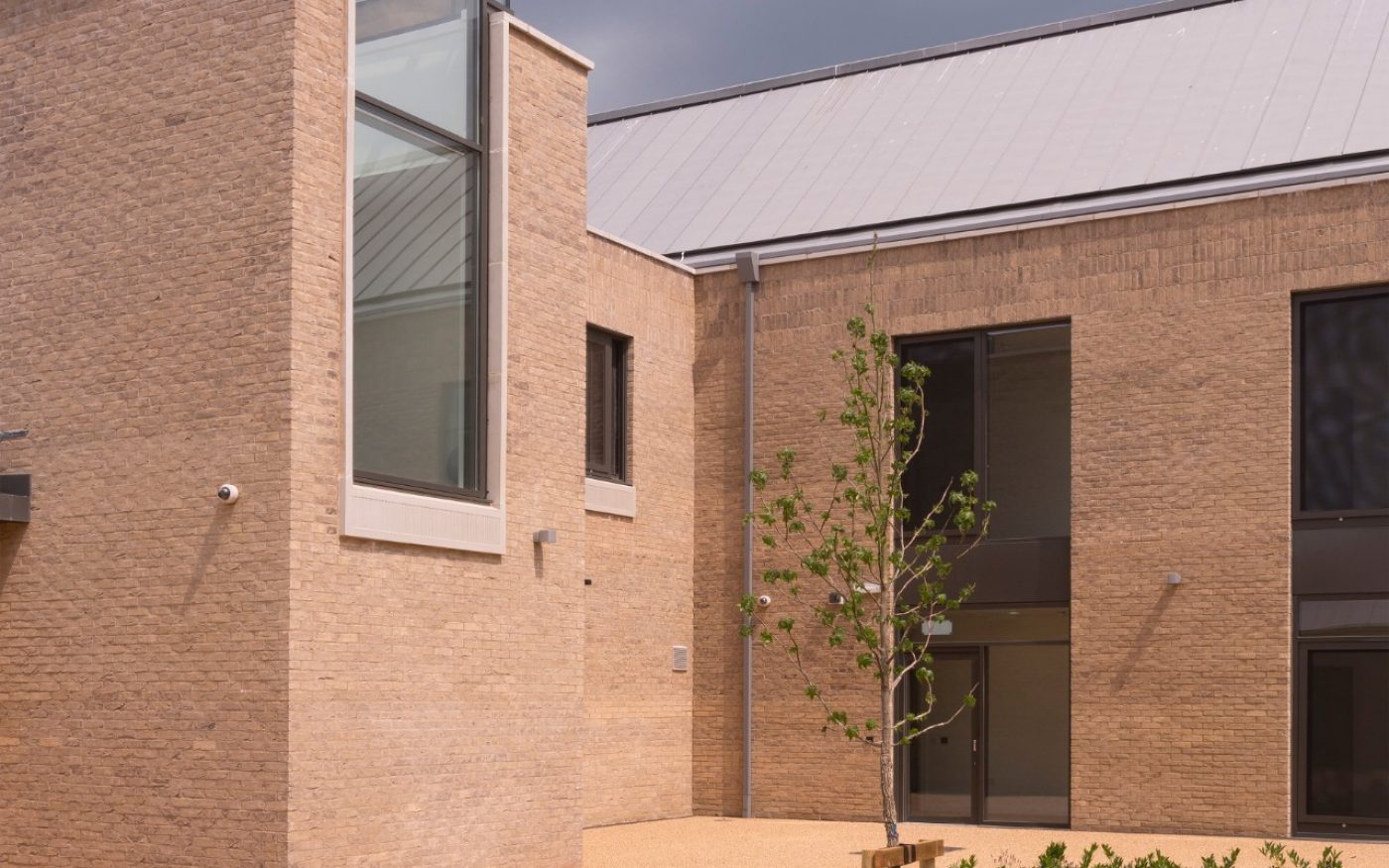Modern building with large windows and paved courtyard area