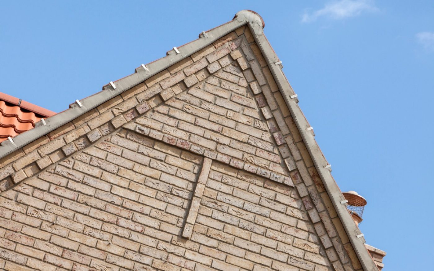 Brick detail at the top of the building with blue sky behind