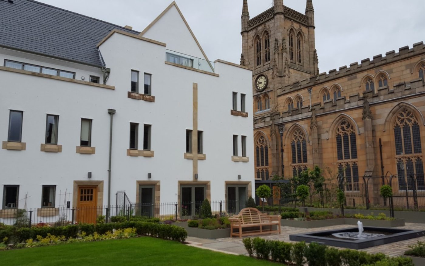 White building next to traditional Cathedral in Blackburn