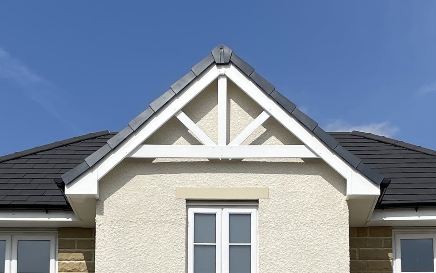 Close up of white beams contrasting with the dark roof tiles
