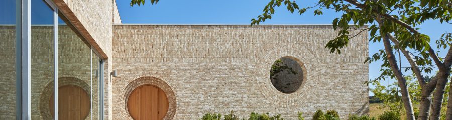 Exterior of Storey's Field contemporary brick architecture with circular door and window