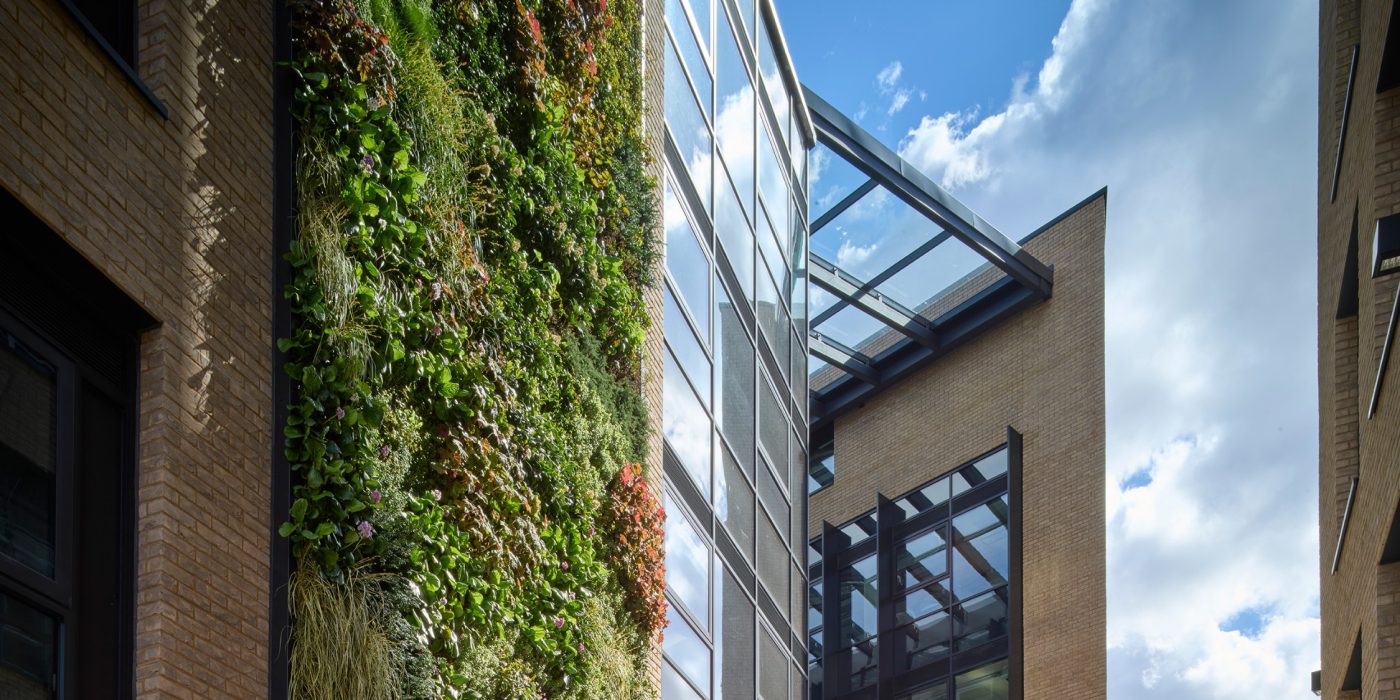 Living grass wall on exterior of modern brick and glass office building