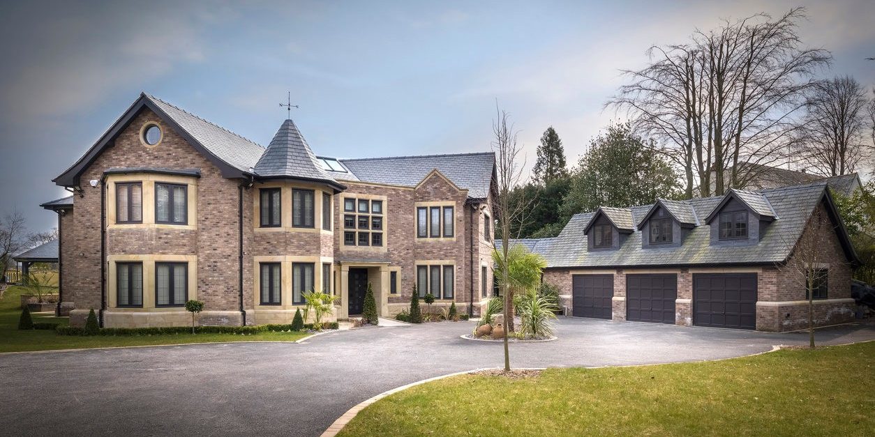 Large modern brick house with tower and detached garage