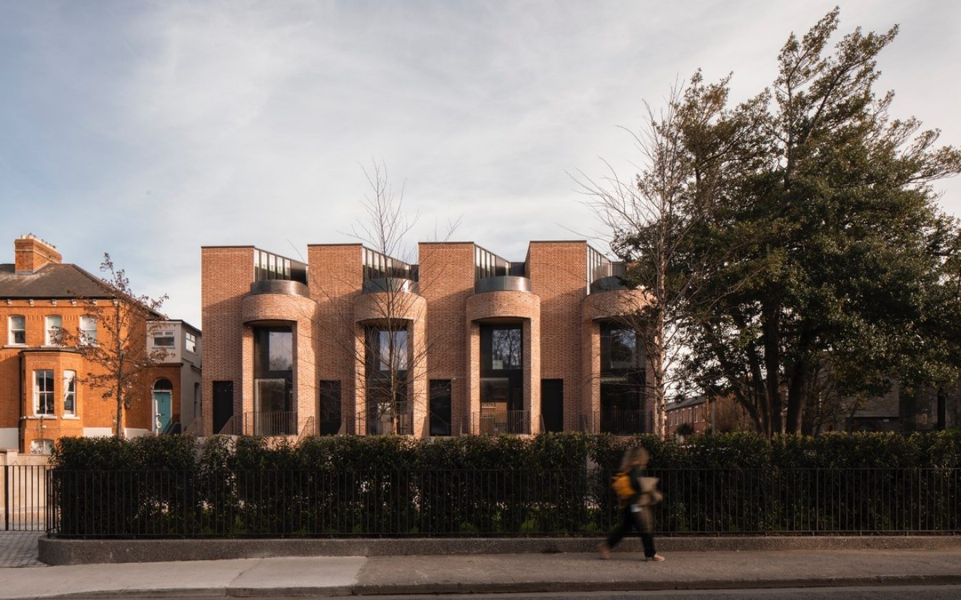 Modern Dublin townhouses with someone walking past on the pavement outside the properties