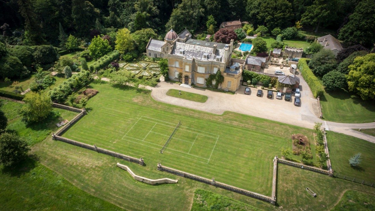 Grounds of a lavish country stately home with walled perimeter and green lawns