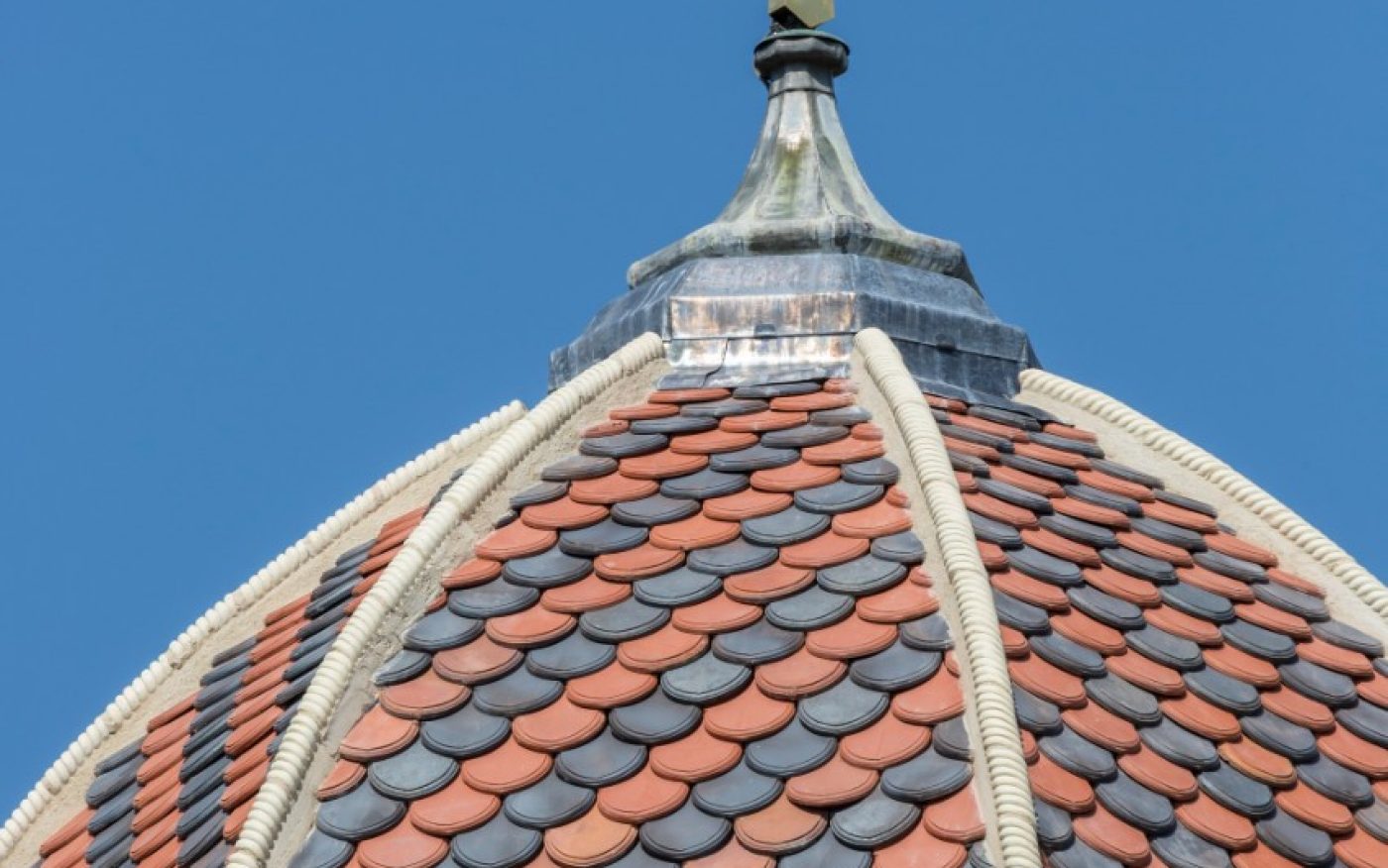 Red and grey tiled dome roof against blue sky