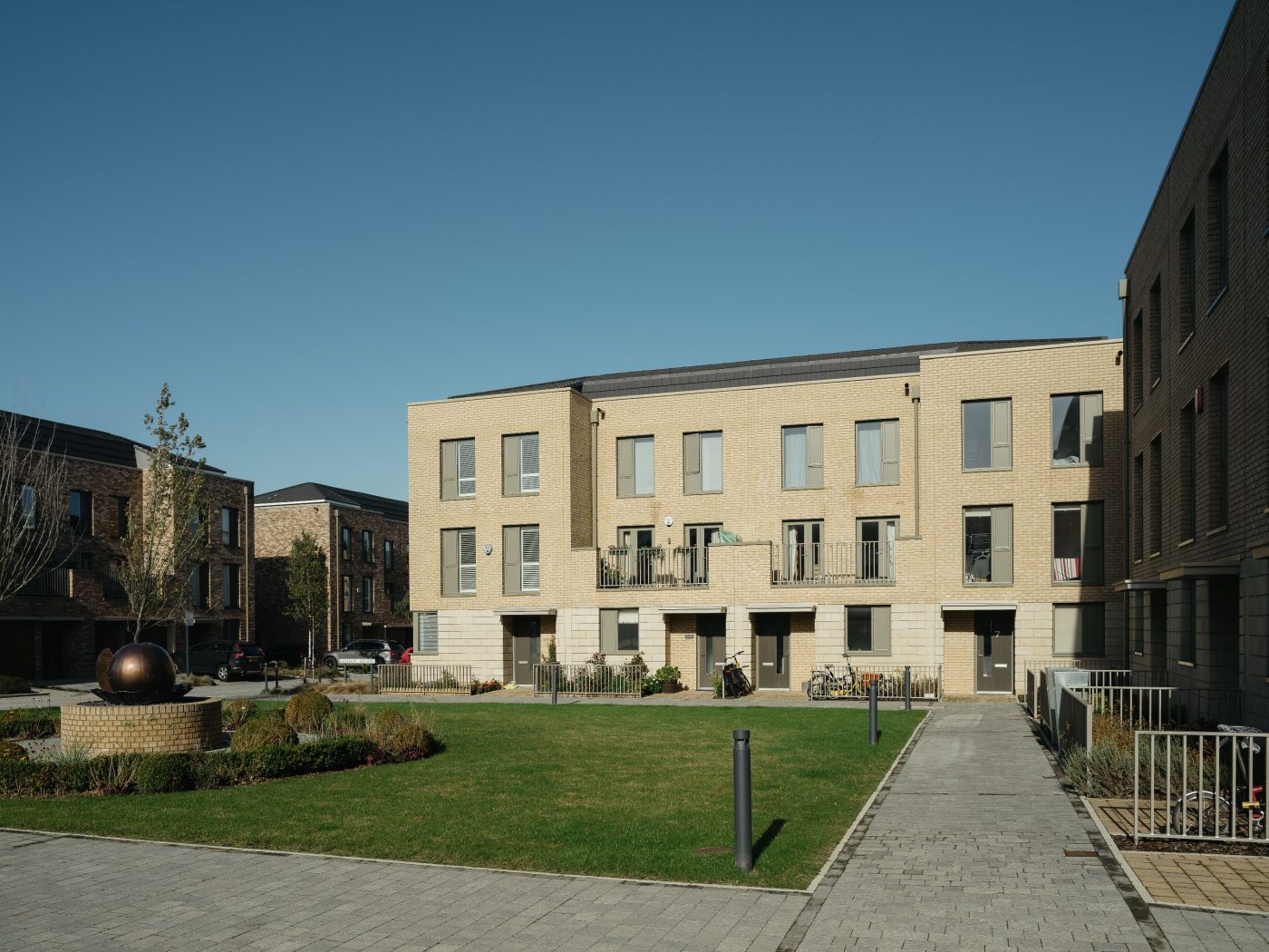 Buff coloured brick multi-residential building with lawn in front