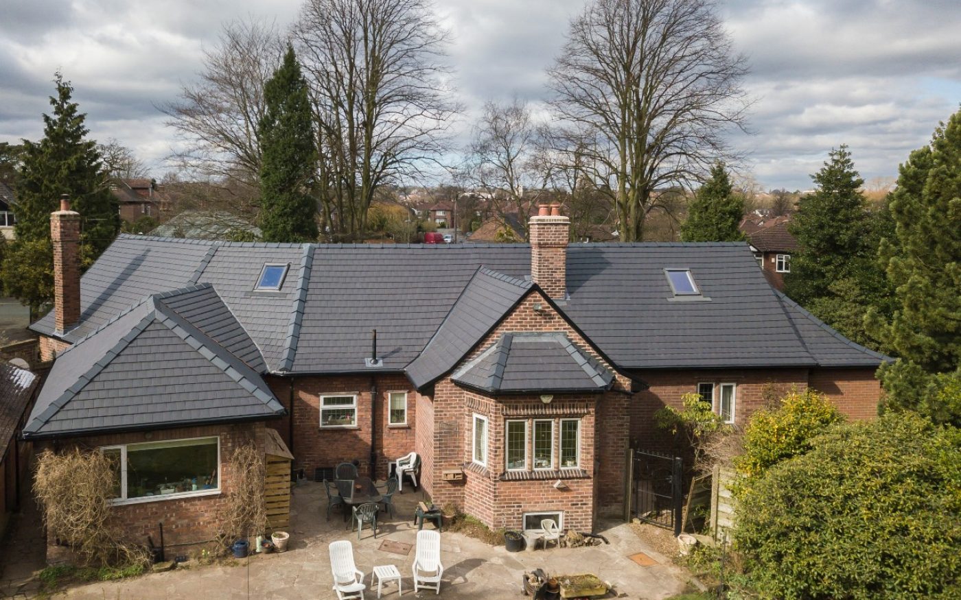 Exterior of brick house with bay window, with newly renovated roof