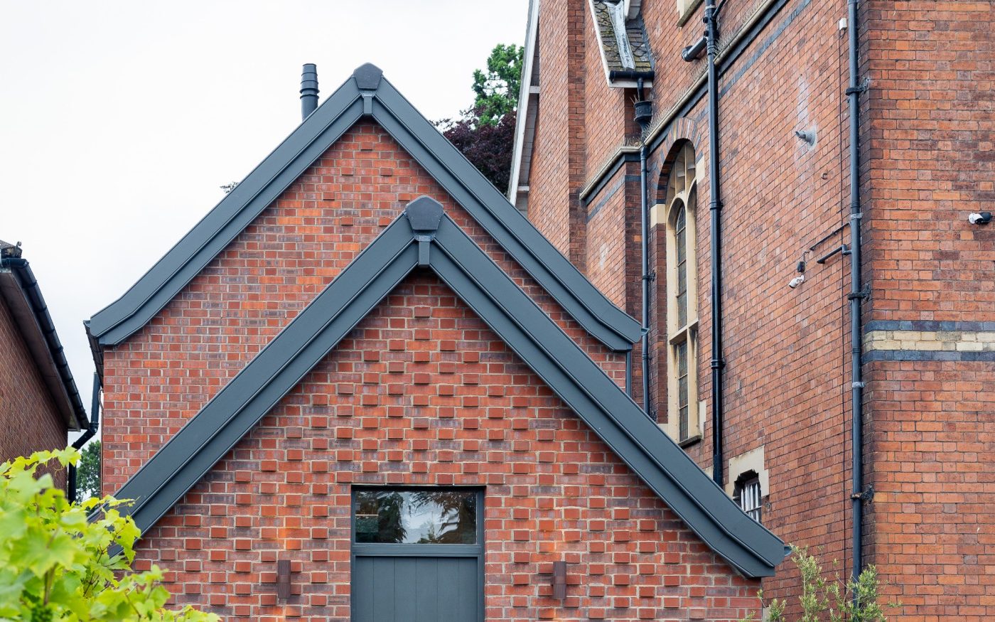 Red brick slim design home in between other properties