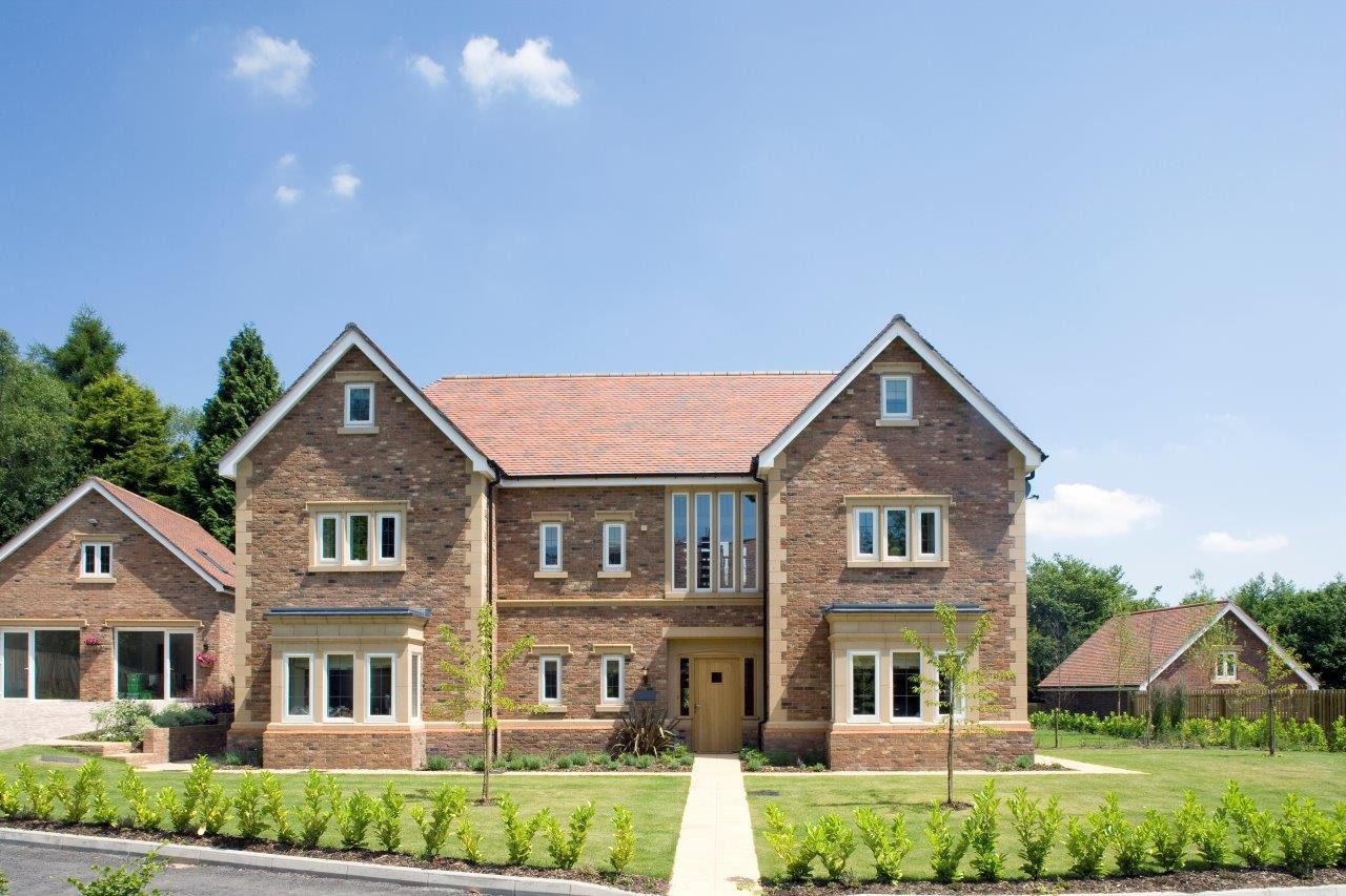Modern detached manor with garage, against blue sky