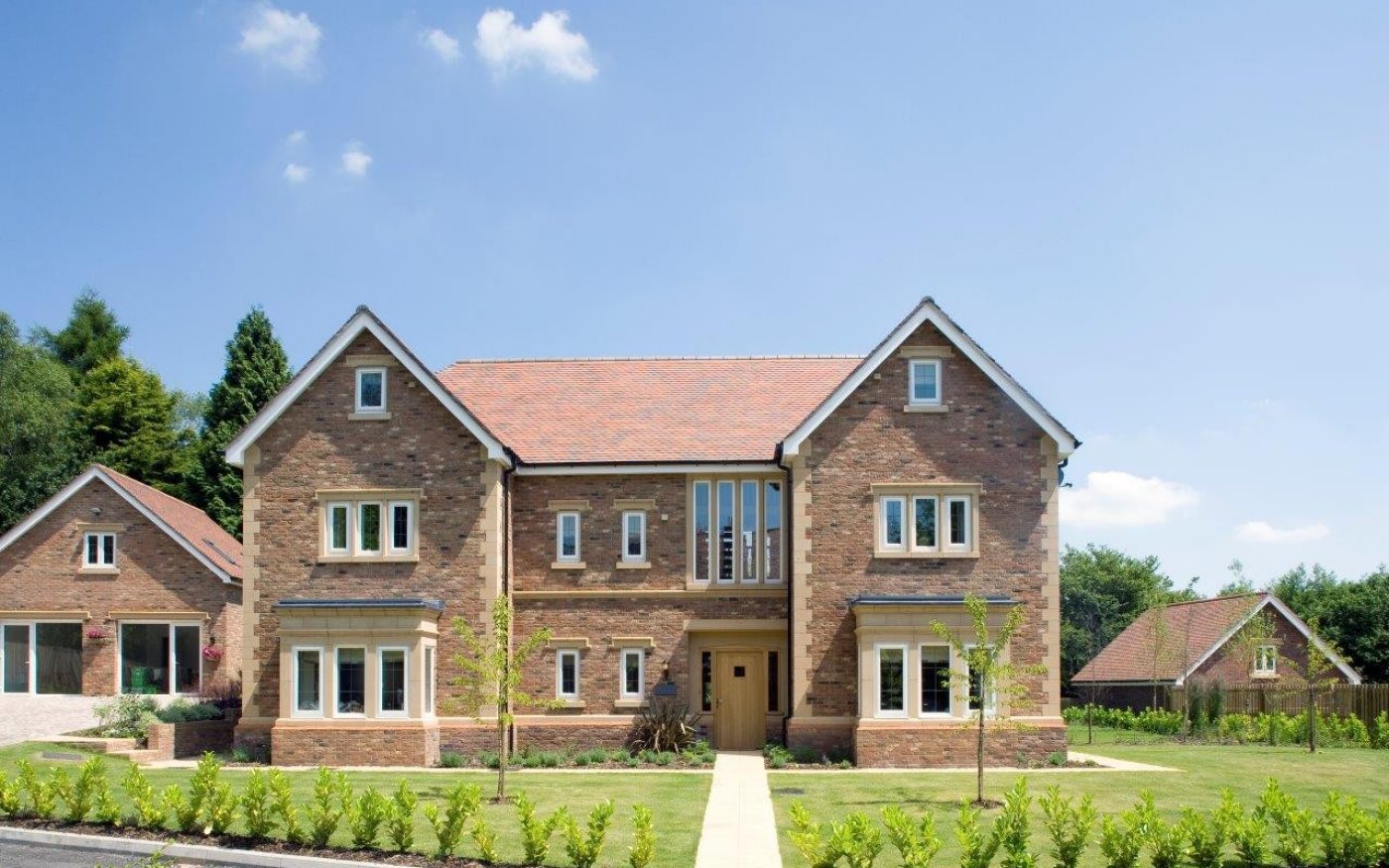 Front of modern brick house with pathway and lawn