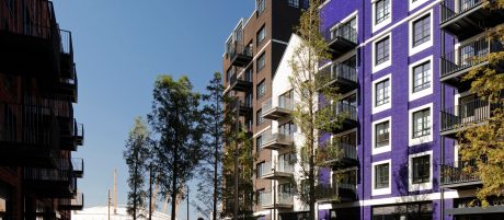 several high-rise buildings with trees and a prominent purple brick building on the right