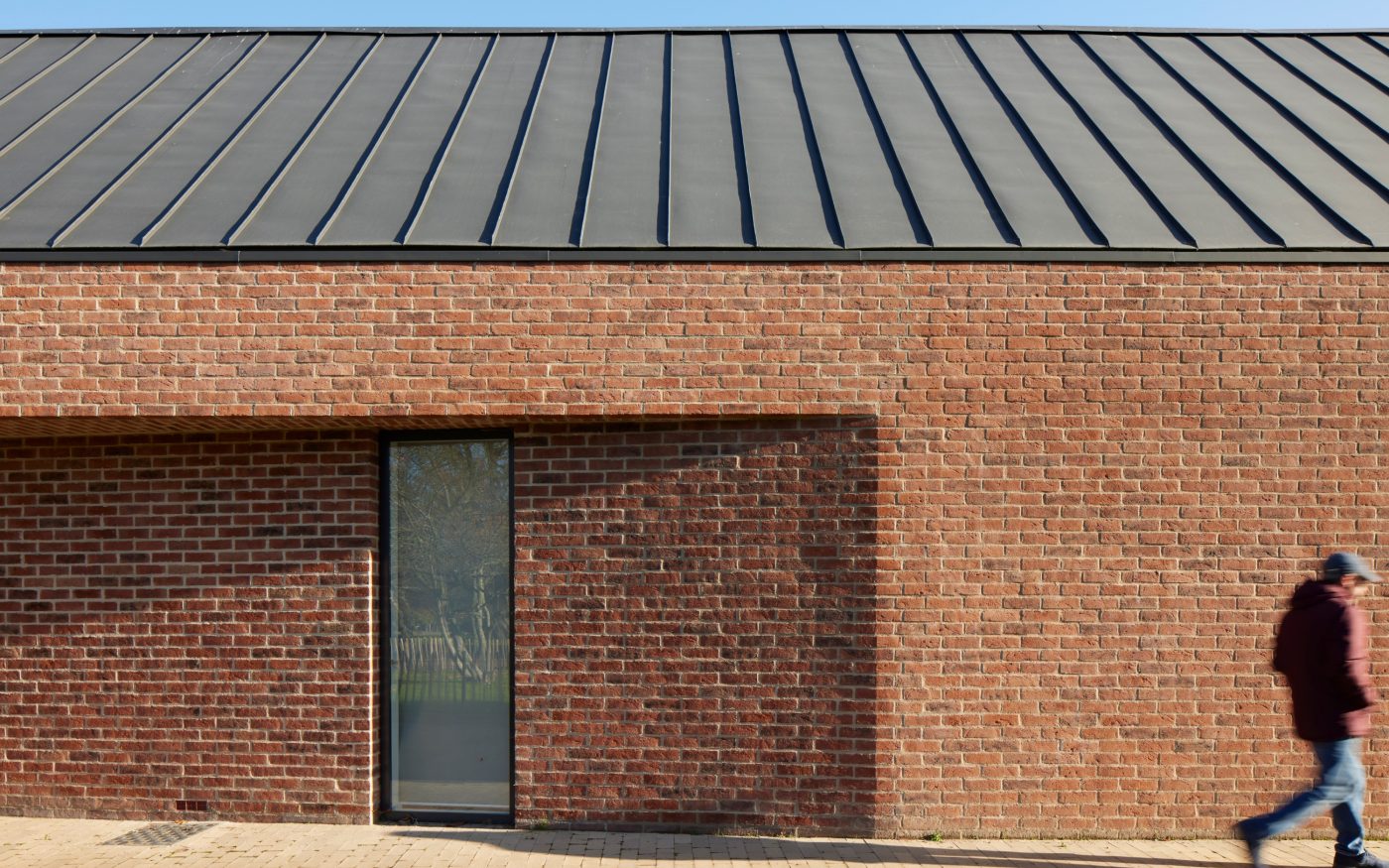 Man walking past brick building