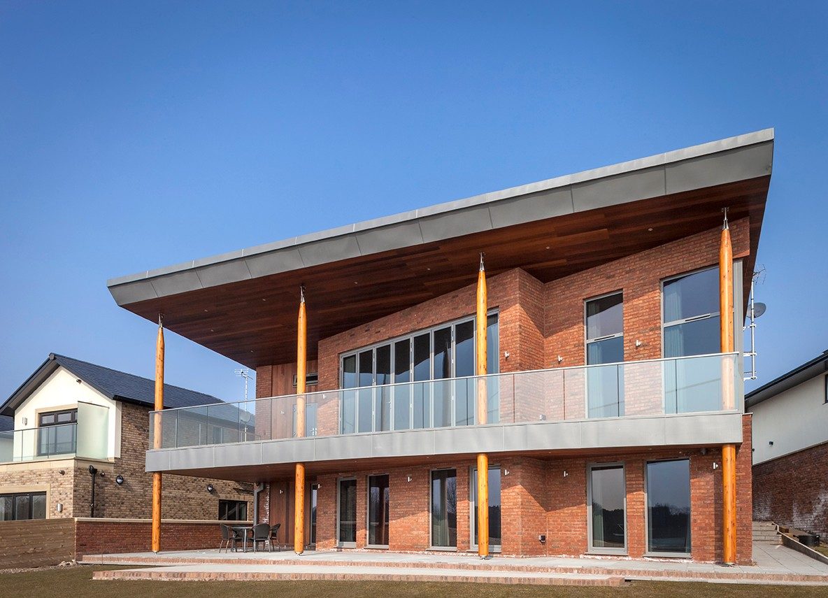 Two-storey modern brick house with large balcony and patio