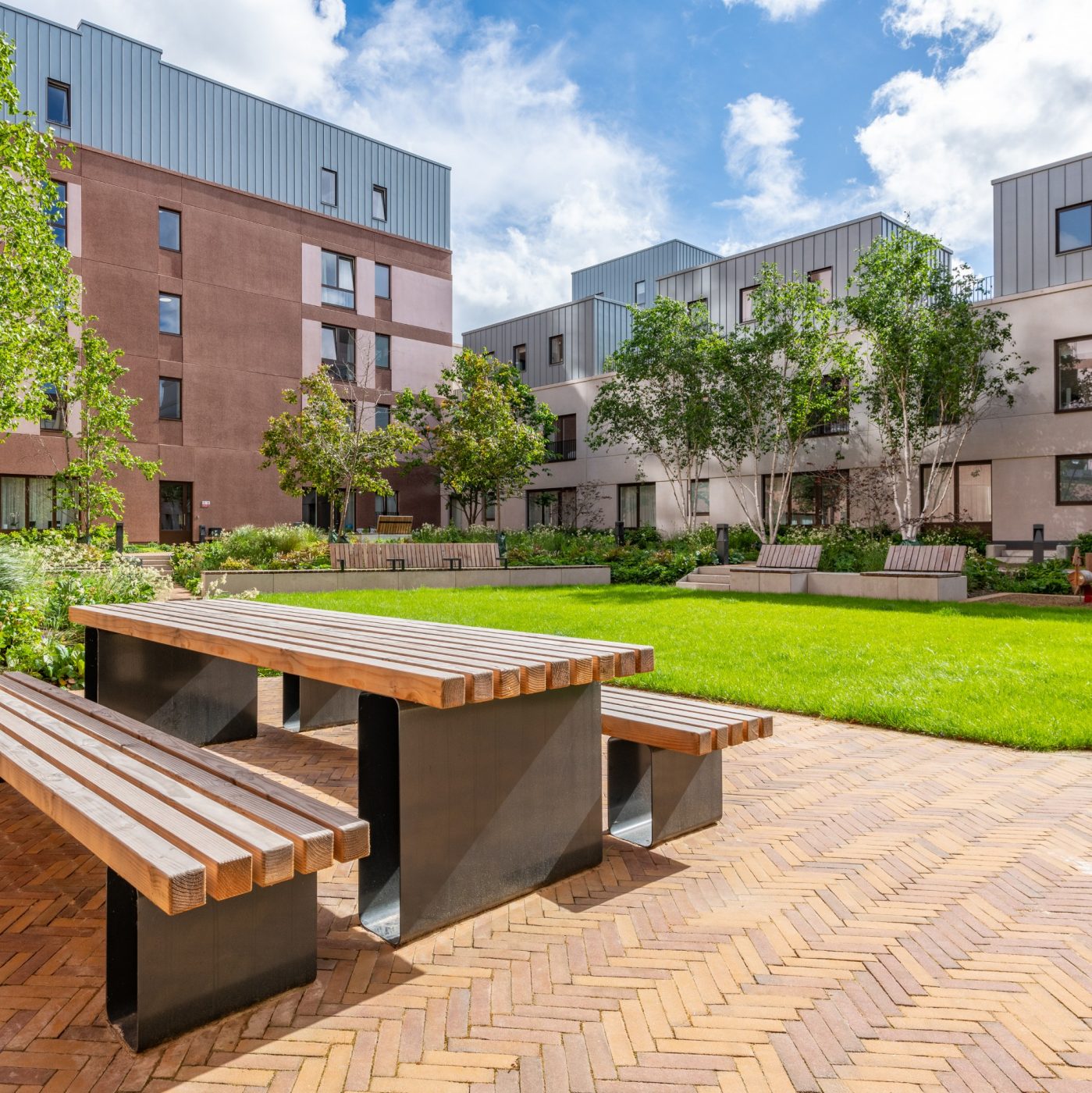 Sunny courtyard with paved landscape and picnic bench