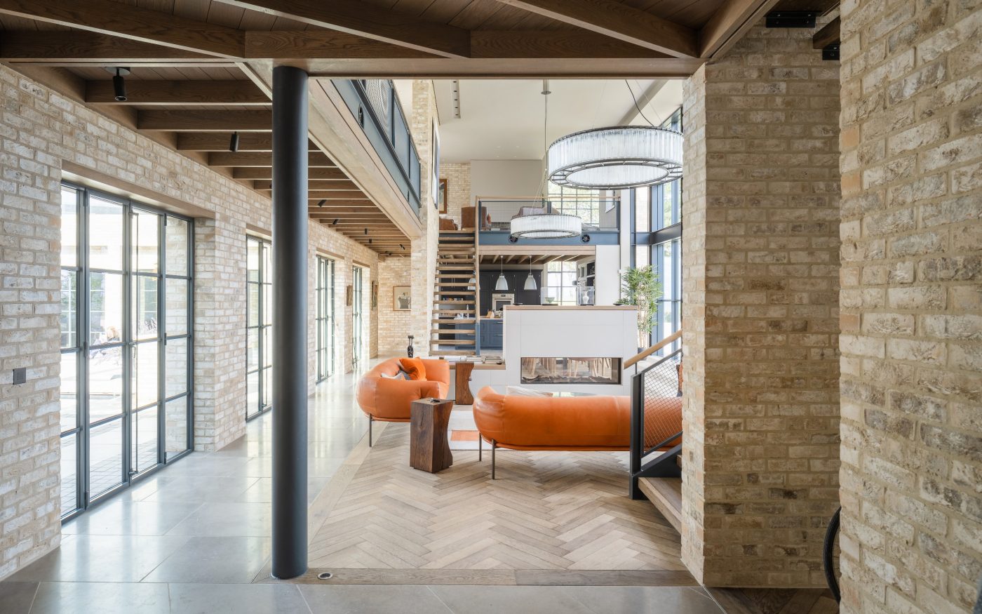 Interior living space with exposed  Marziale Brick walls and orange sofas