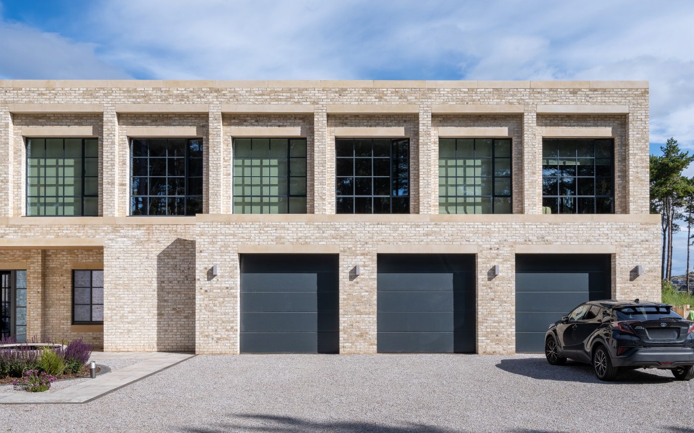 Shot of building with three garage doors and car outsideshowing Wienerberger Marziale Brick