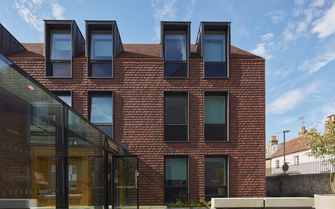 Exterior of modern accommodation block at boarding school with vertical tiled walls and large windows