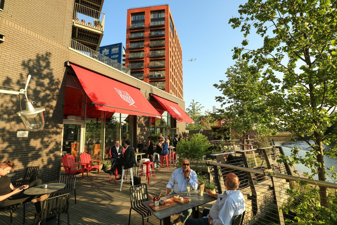 People sitting outside a cafe in sunshine on London City Island
