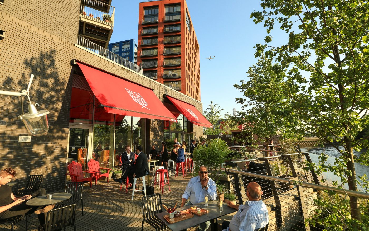 People sitting outside a cafe with high-rise buildings in the background