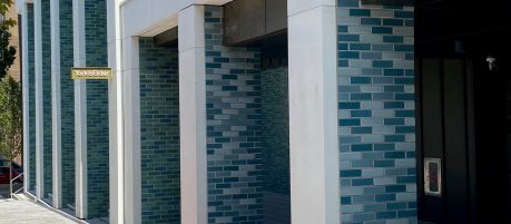 Different Shades of blue and green glazed bricks on modern apartment building entrance