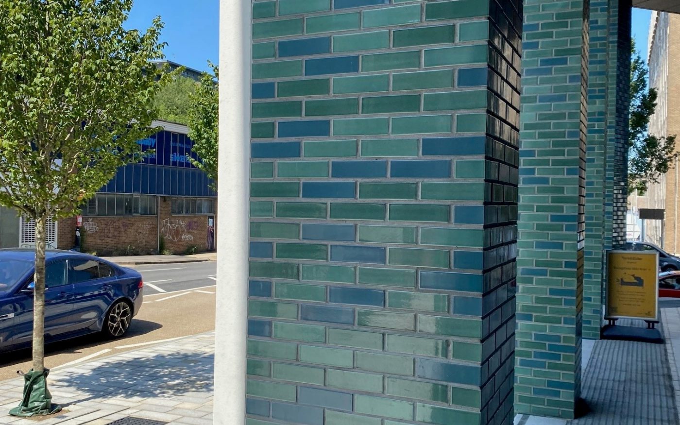 Green and blue glazed brick columns outside Longley Place apartments
