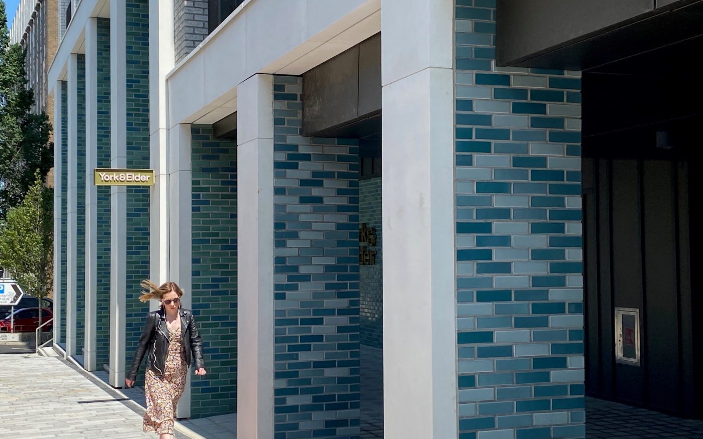Woman walking past modern apartment building