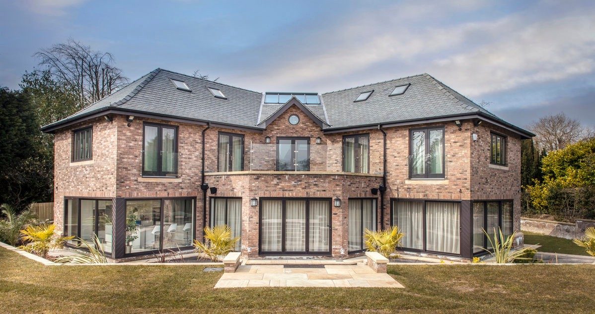 Large modern manor house with balcony and landscaped garden