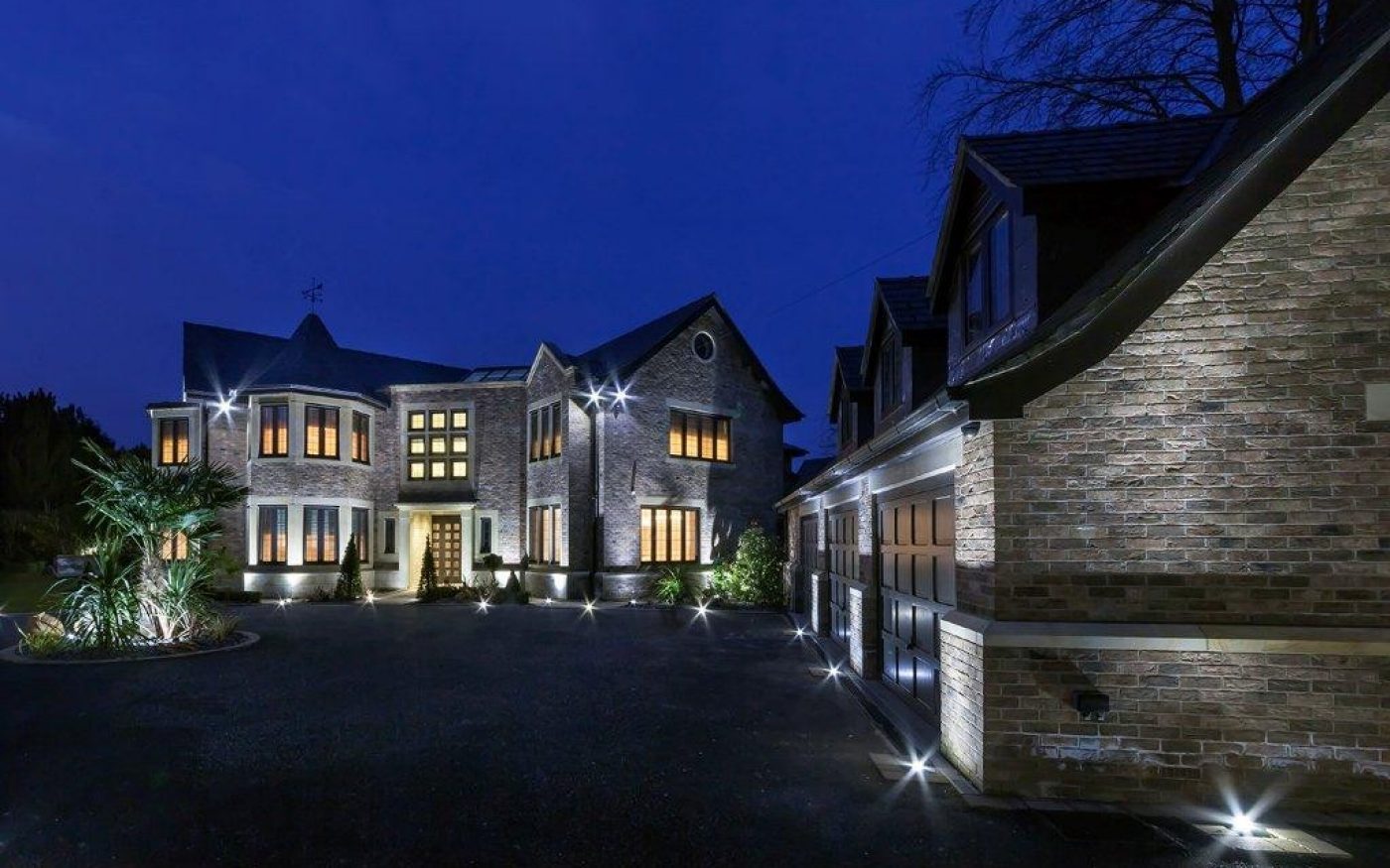 Large brick country house lit up at night