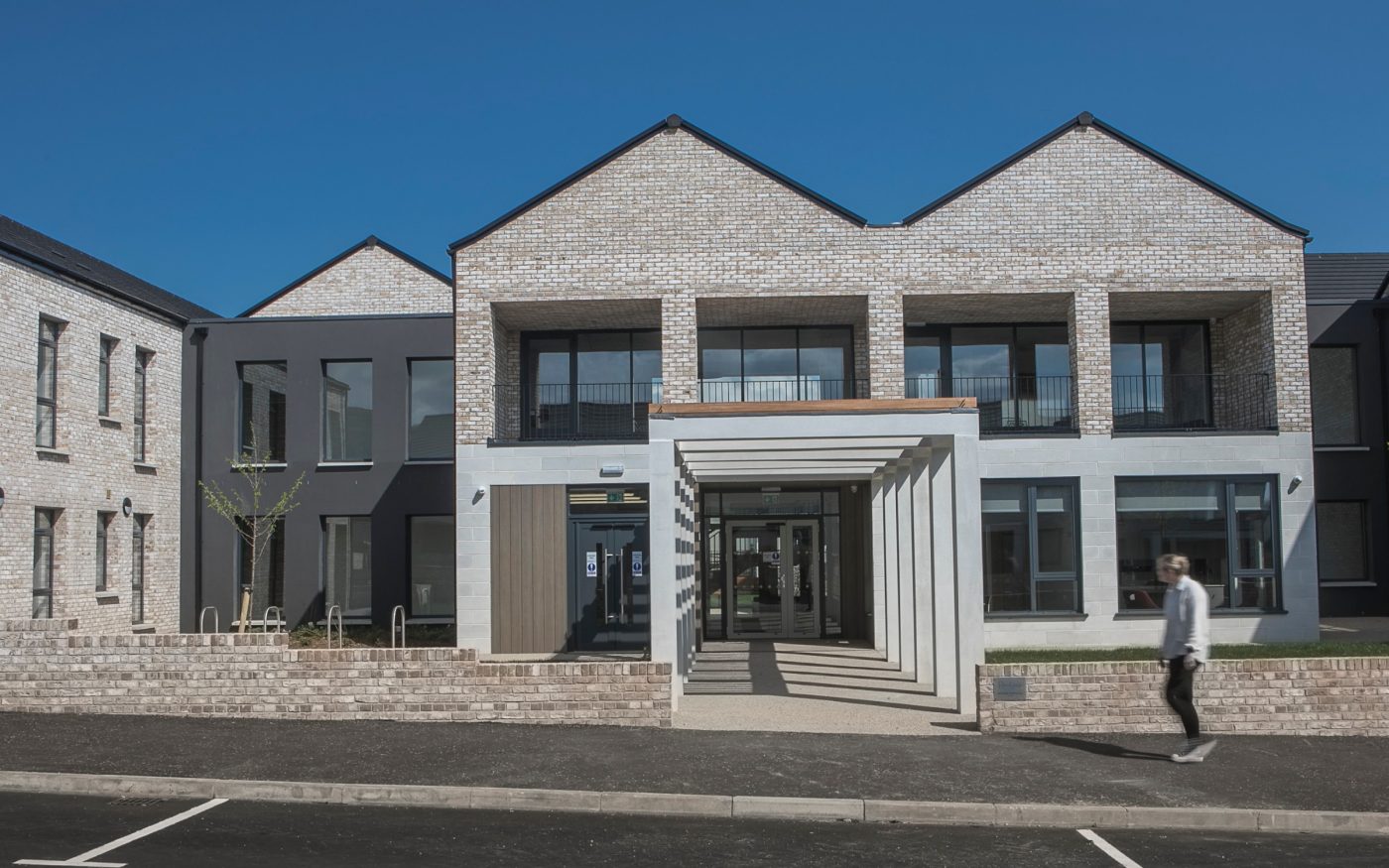 Entrance to the residential complex with a man walking past on the right