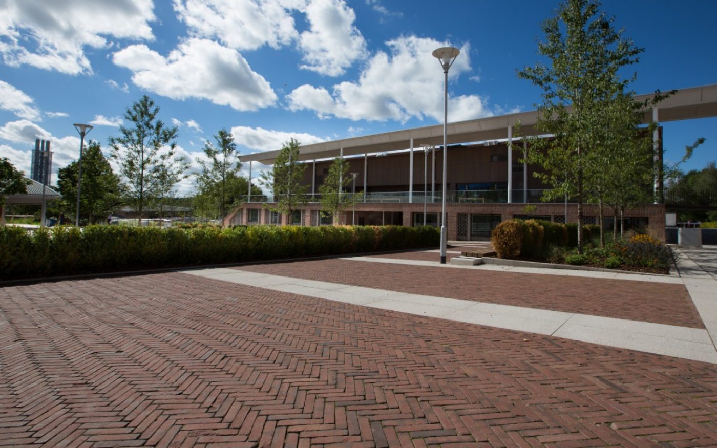 Herringbone pattern clay paving and trees in front of university