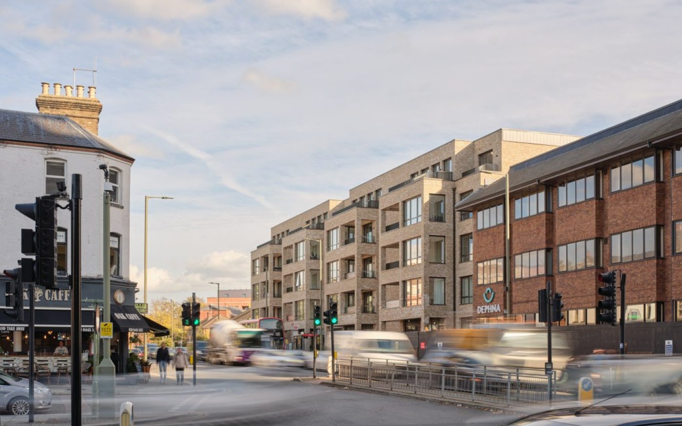 Bustling street in london with the newly developed building on the right side and a traditional pub across