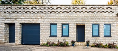 modern buff bungalow with dark window panes and door