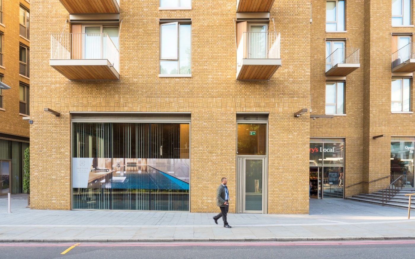 man walking down the street outside One Tower Bridge building