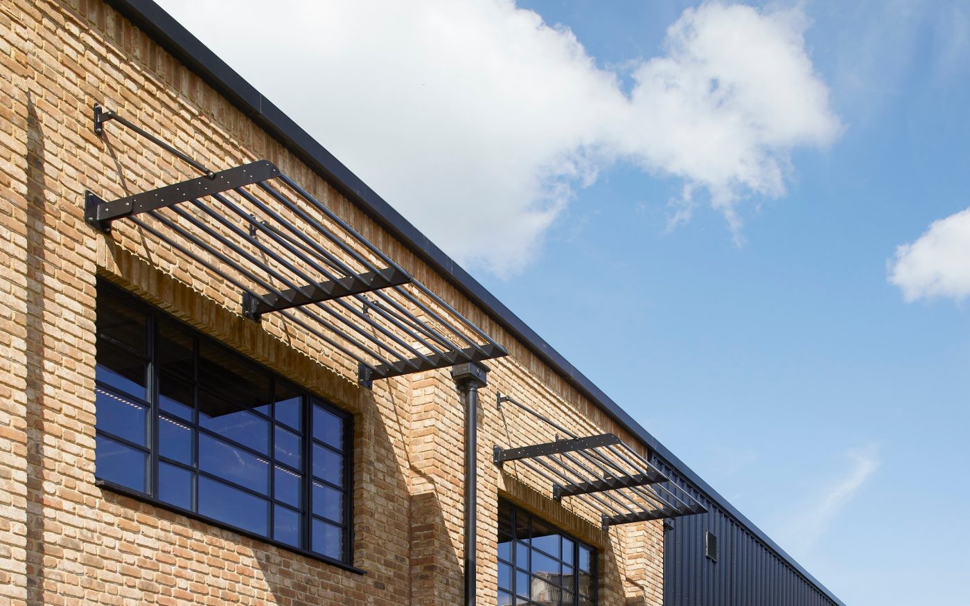 Black metal brackets above the windows of the building