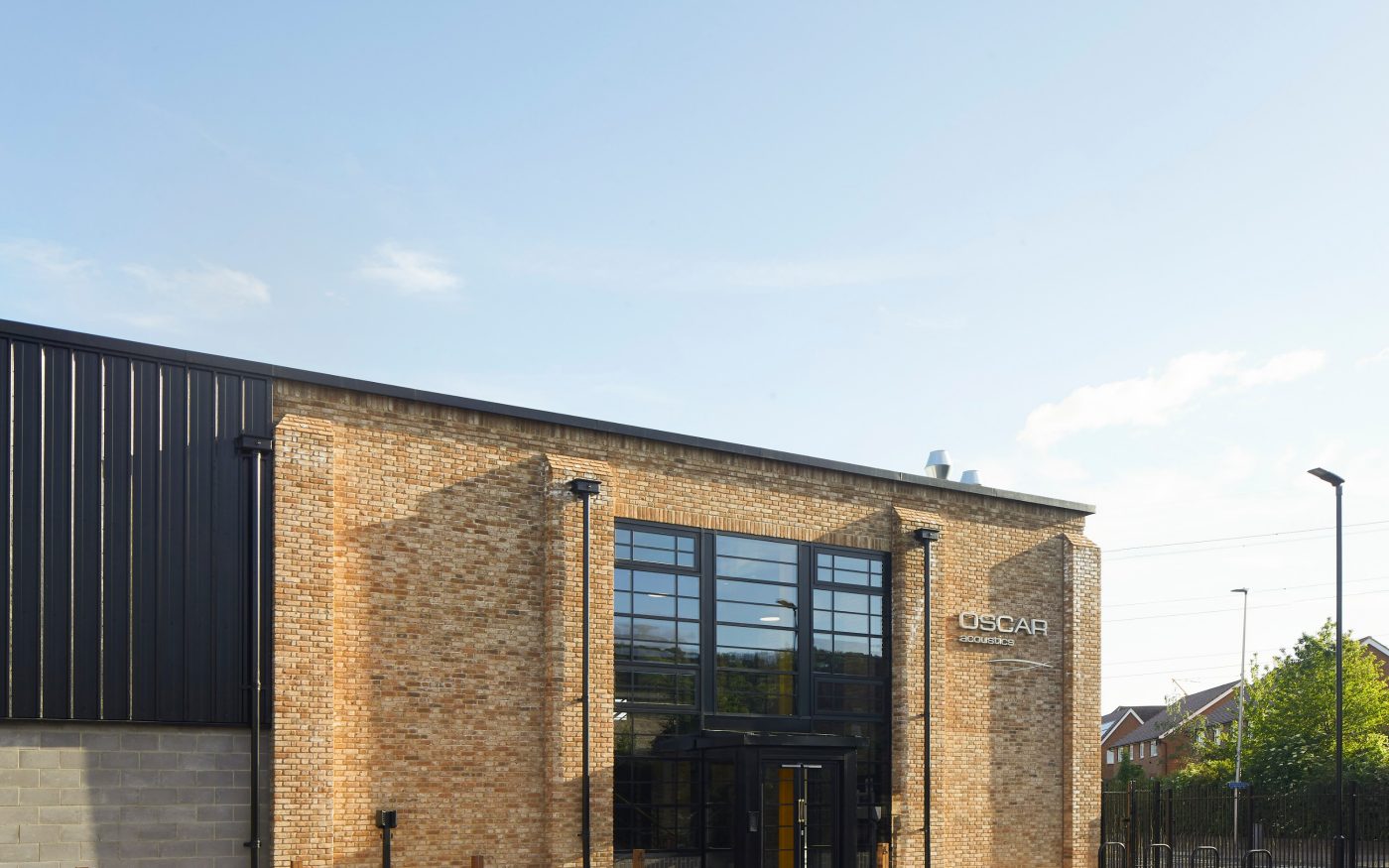modern black panelling on the left contrasts with the light brick of the building