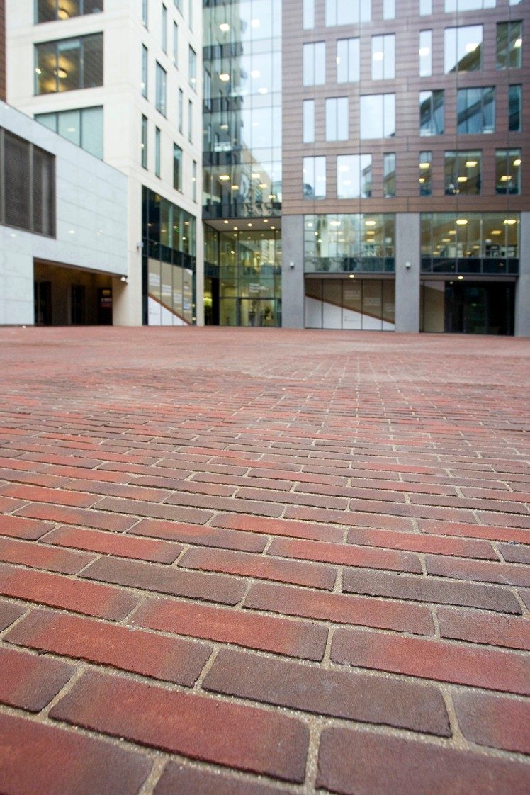 Red clay paving area outside modern office buildings
