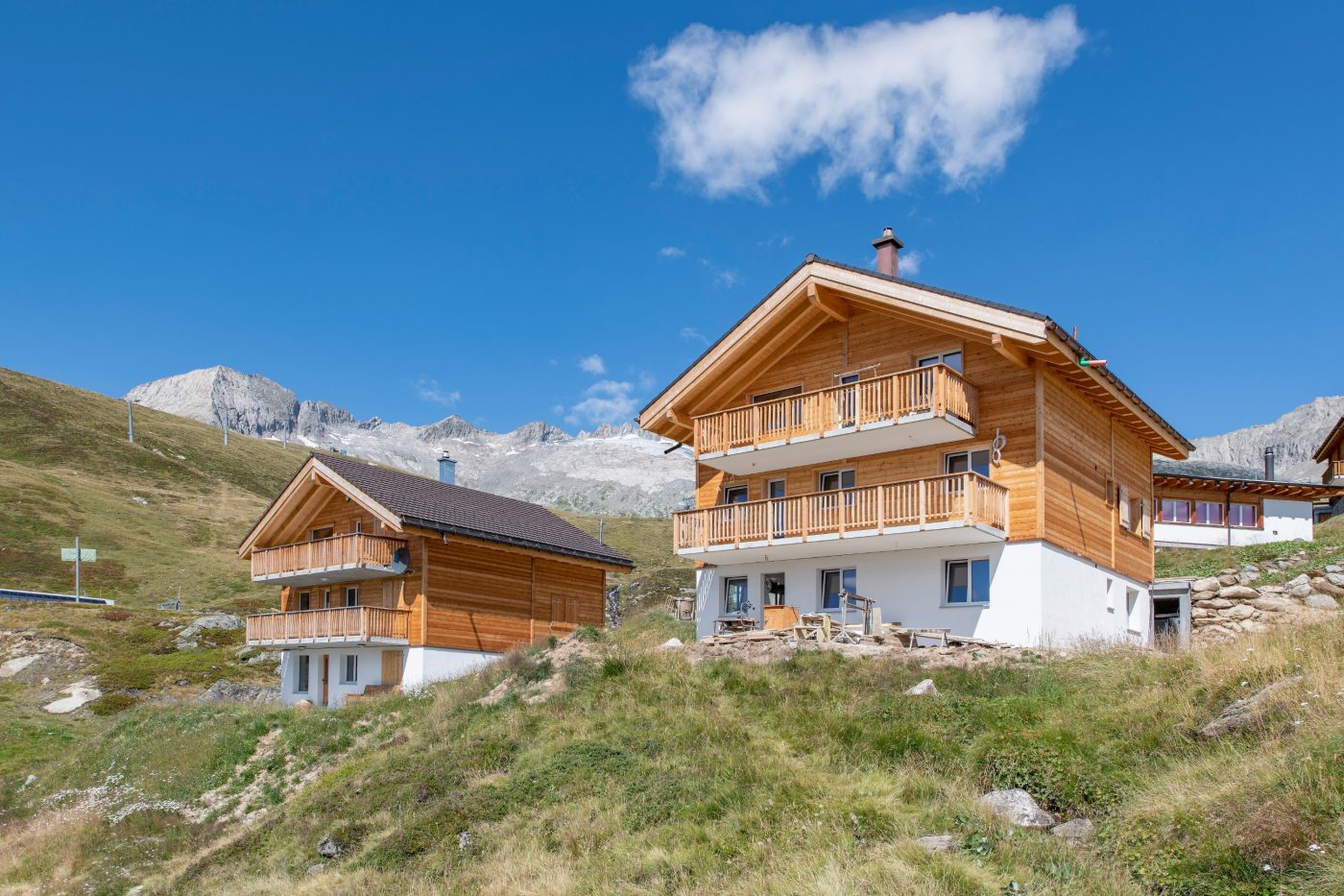 Contemporary alpine chalet buildings against blue sky and mountain range