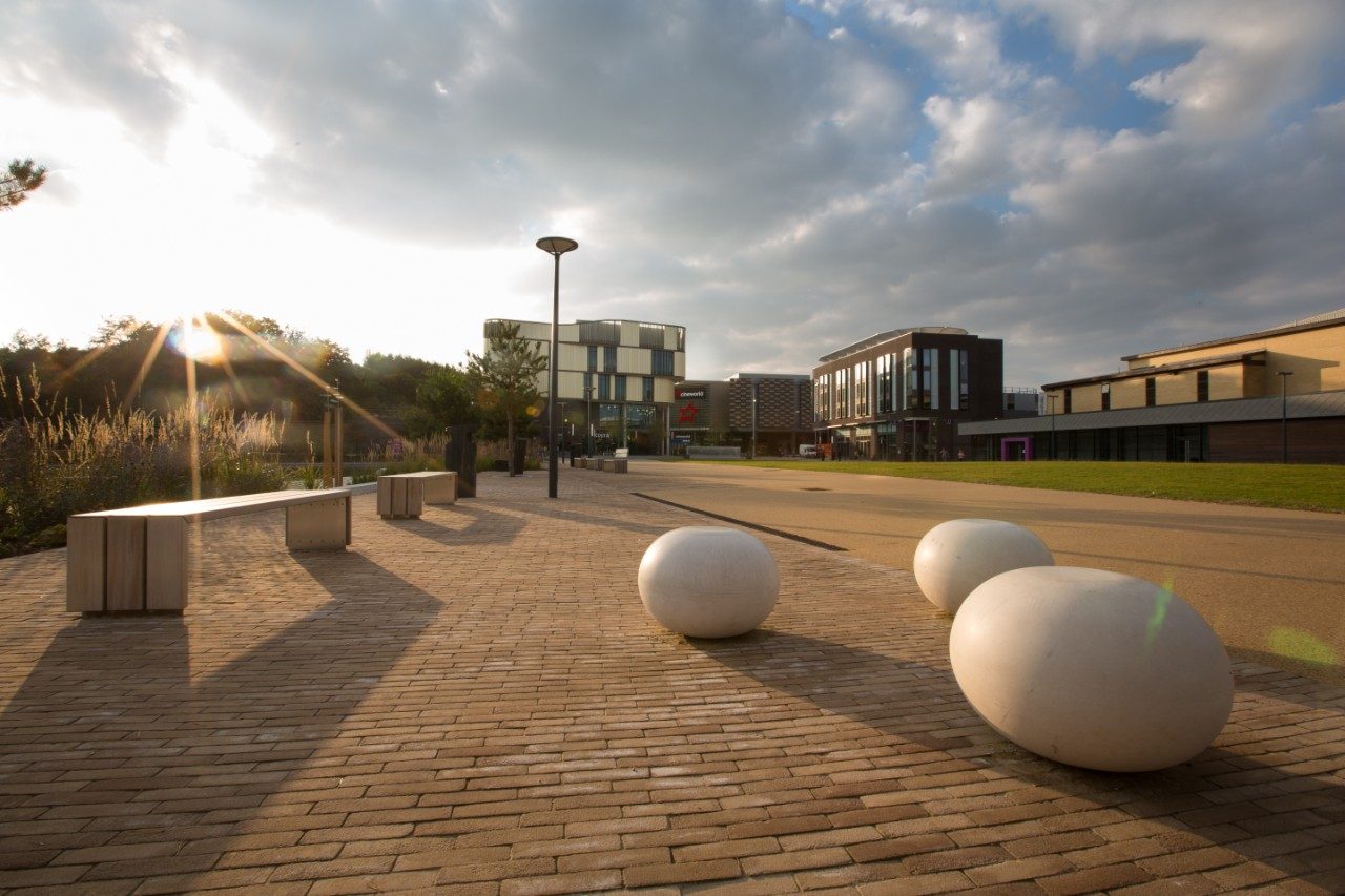Paved outside area with benches and modern sculptures