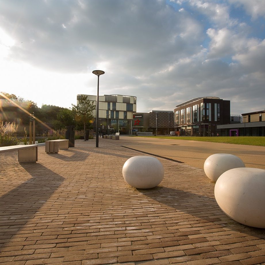 Paved outside area with bench and modern sculpture