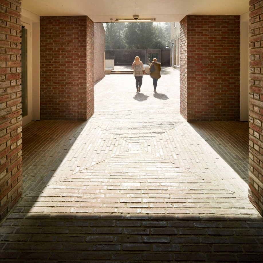 Two people walking arcoss paved courtyard