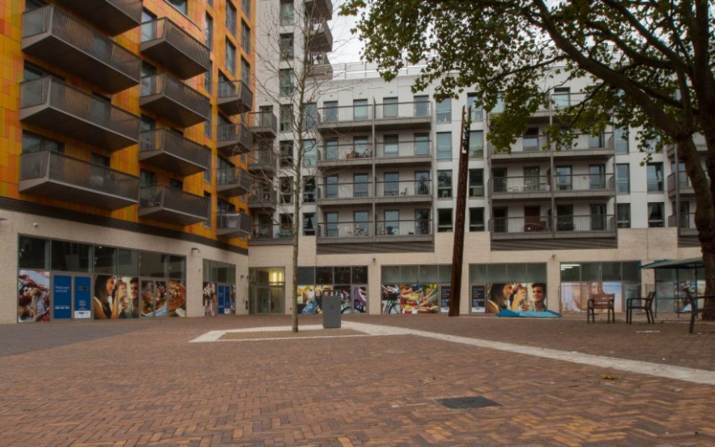 Herringbone paved walkway surrounded by shops and high rise buildings