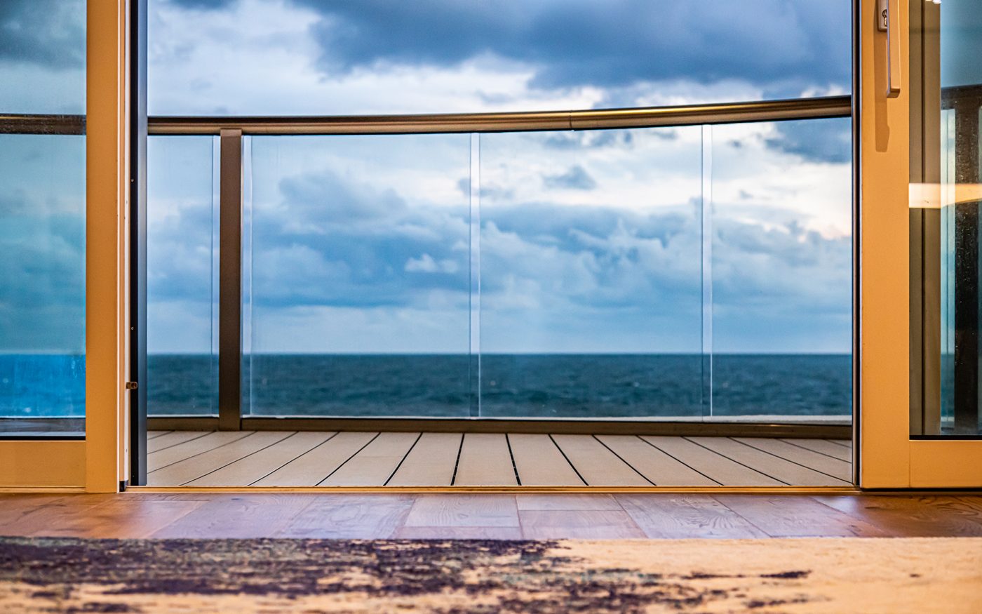 View through glass windows to balcony overlooking the sea