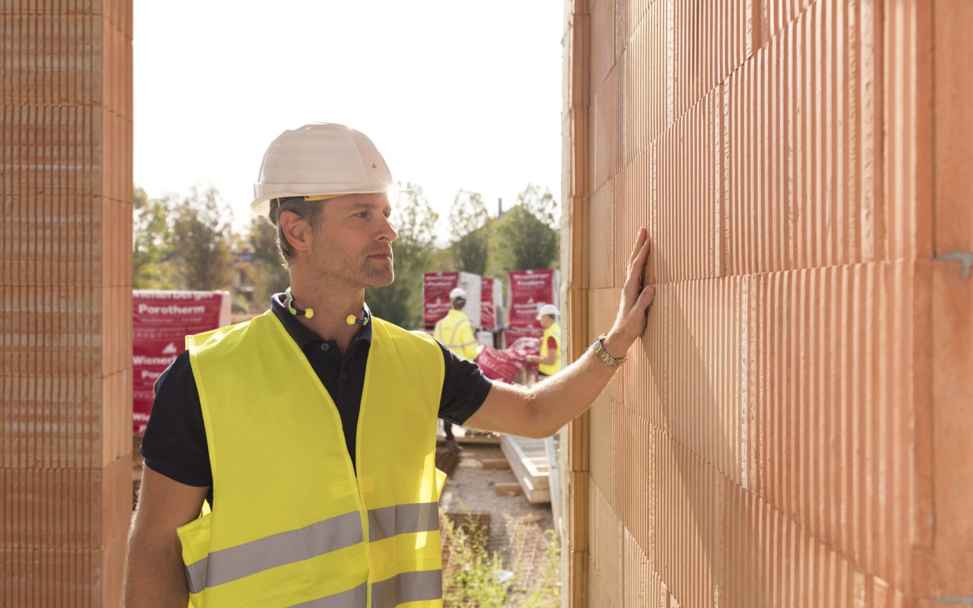 Man inspects Porotherm clay block wall
