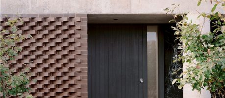 Close up of large front door with bushes surrounding